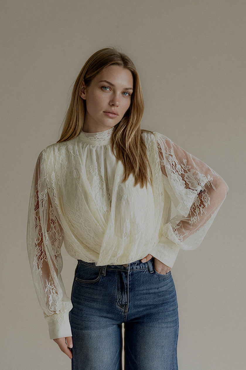 Blouse CAMILLE écrue à manches en dentelle portée avec un jean bleu, silhouette entière de face