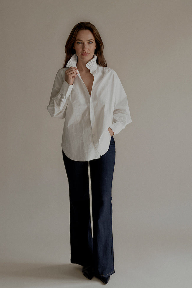 Chemise CLARISSE blanche en coton portée avec un jean bleu marine

