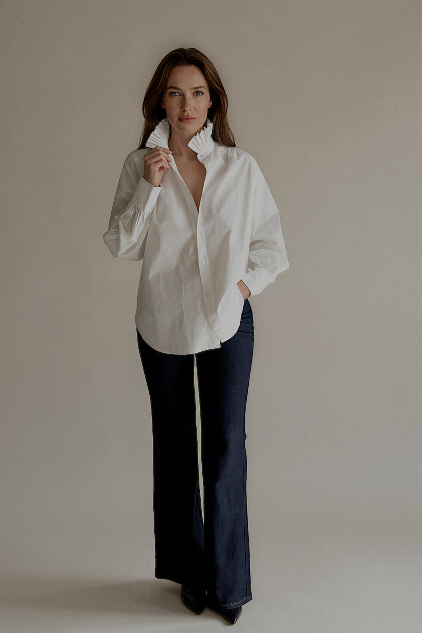 Chemise CLARISSE blanche en coton portée avec un jean bleu marine

