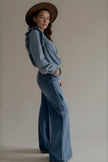 Chemise CLÉO en denim bleu portée avec un jean et un chapeau marron