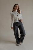 Chemise CYBÈLE en dentelle blanche portée avec un jean gris, silhouette entière
