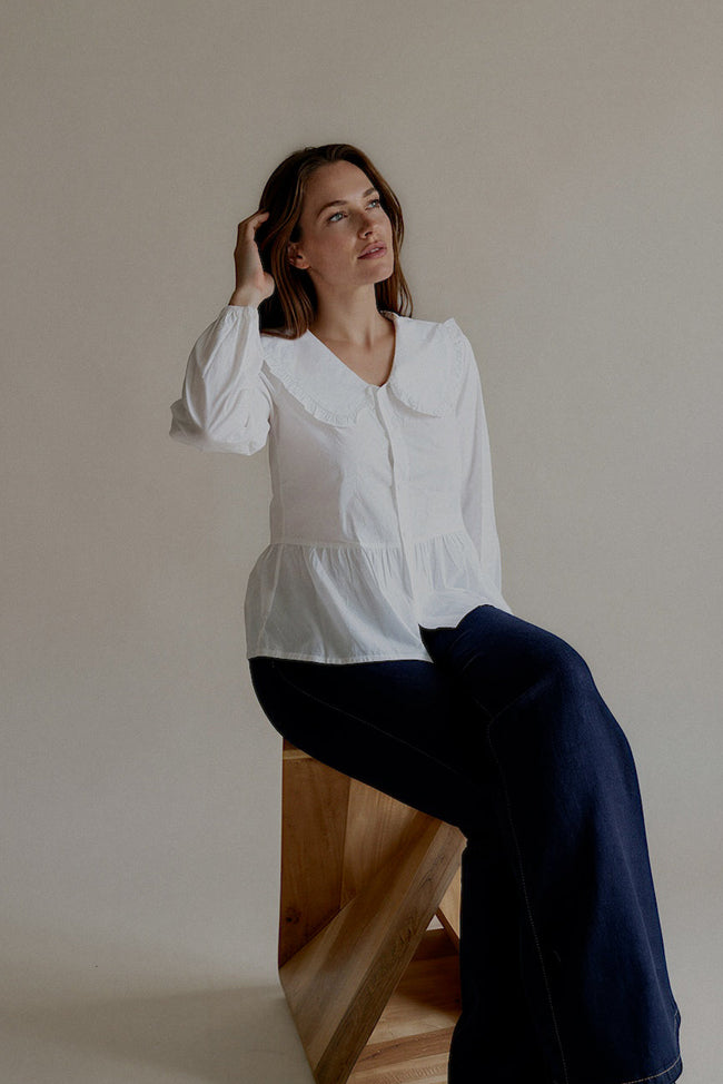 Chemise CÉLESTINE blanche à la coupe féminine, modèle assis

