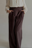 Détail du pantalon PIPPA marron – plis, taille haute et poche