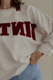 Détail du sweat SIXTINE gris chiné et de son inscription bordeaux en matière éponge