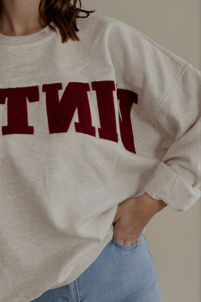 Détail du sweat SIXTINE gris chiné et de son inscription bordeaux en matière éponge