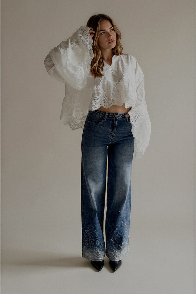 Jean PAIGE bleu à la coupe large porté de face avec une blouse blanche