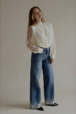 Jean PAIGE bleu à strass, vue de trois quarts avec une blouse blanche