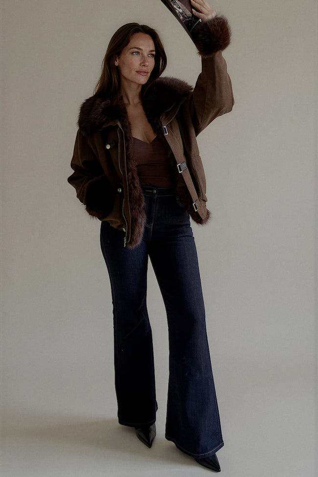 Jean PIPER en denim brut porté avec une veste marron et un chapeau