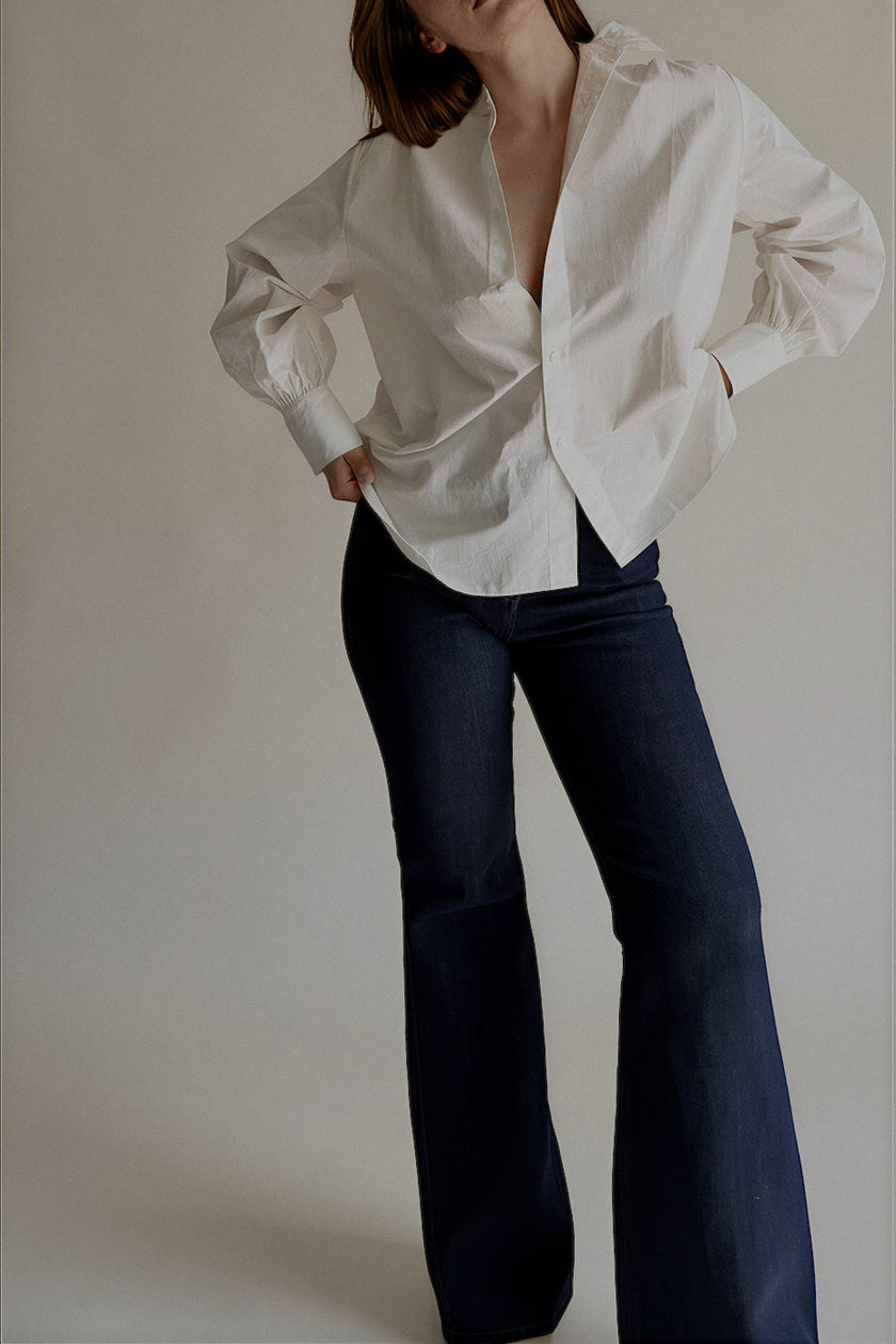 Jean PIPER flare en denim brut porté avec une chemise blanche