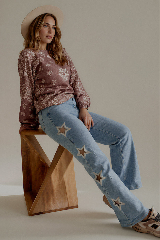 Jean POPPY bleu clair à étoiles porté assis avec le pull MARNIE