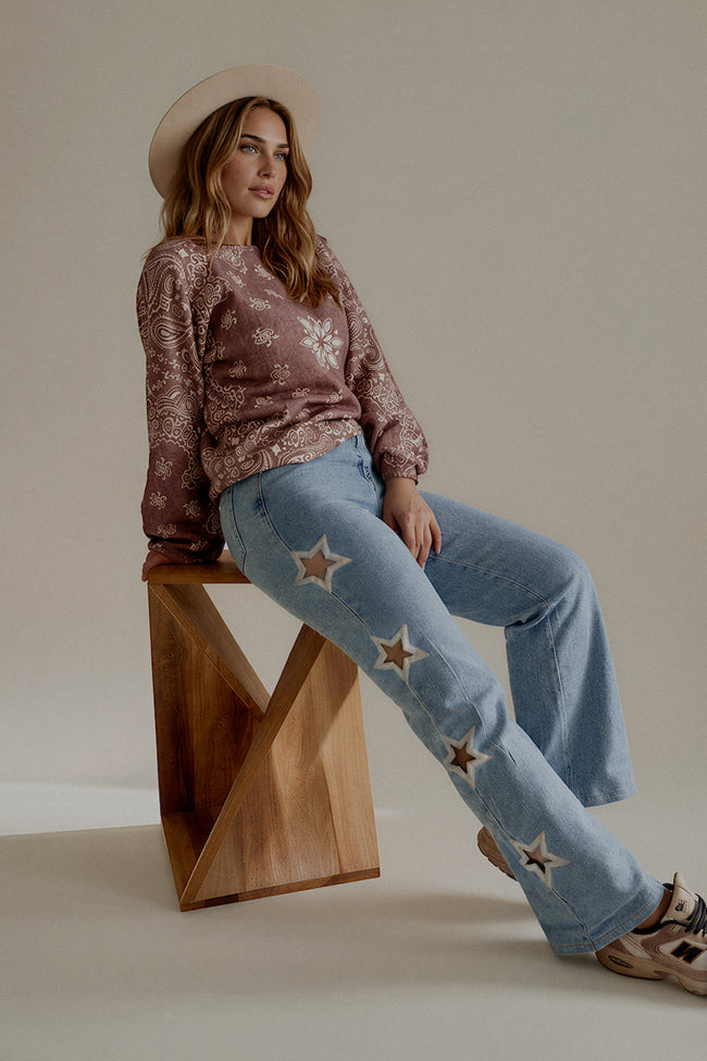 Pull MARNIE imprimé bandana taupe rosé porté assis avec un jean clair