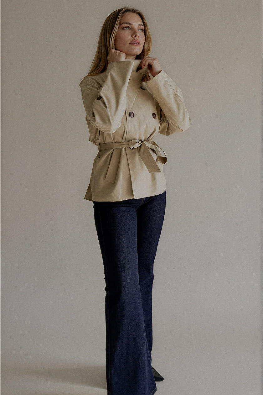 Trench VARENNE court beige ceinturé et porté avec le col montant
