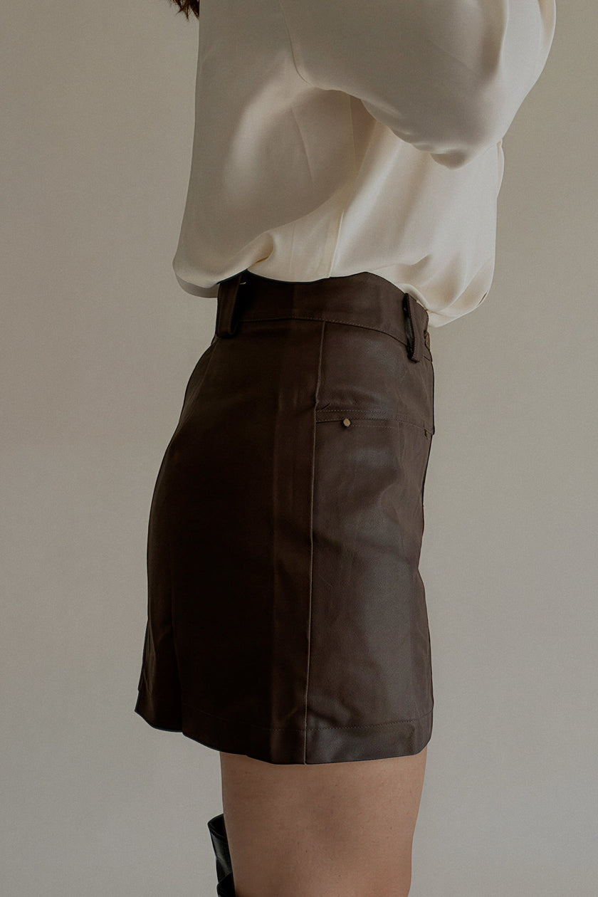 Vue de profil de la jupe-short JOYCE marron effet cuir portée avec des bottes hautes