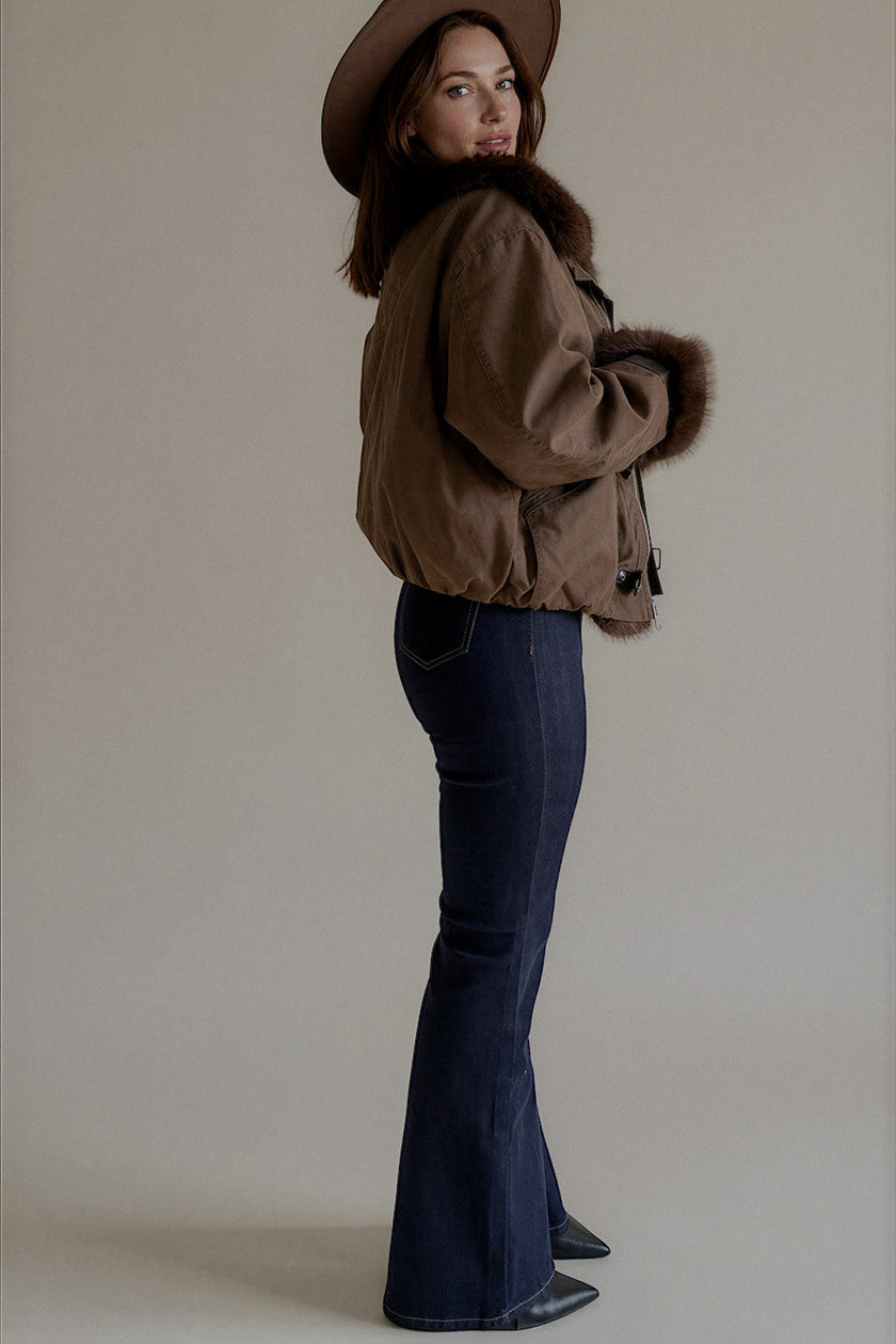 Vue de profil du jean PIPER en denim brut porté avec une veste marron