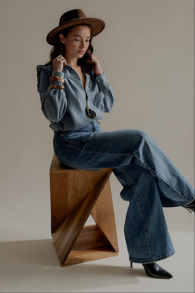 Vue de trois quarts de la chemise CLÉO en denim bleu à volants